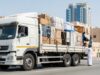 A stressed couple surrounded by cardboard boxes while talking to a mover in Dubai, illustrating the risks of hiring cheap movers in dubai and hidden costs during relocation.